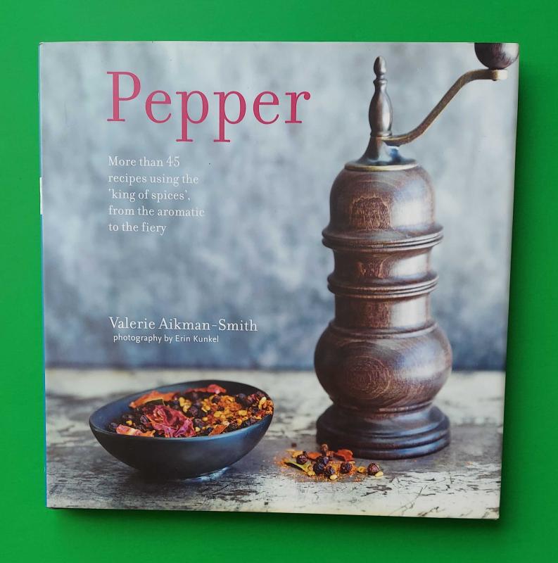  A pepper grinder next to a small bowl of freshly ground pepper.