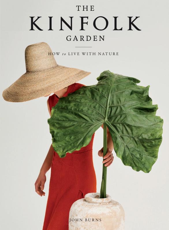 Person with a large straw hat places a dying houseplant leaf into a jar