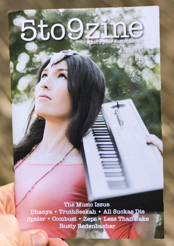 A young woman wearing elven-like jewelery in her hair and a piano slung across her shoulder.