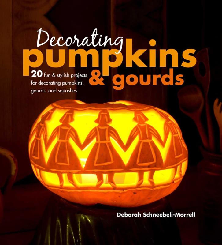 glowing carved pumpkin in the pattern of paper dolls