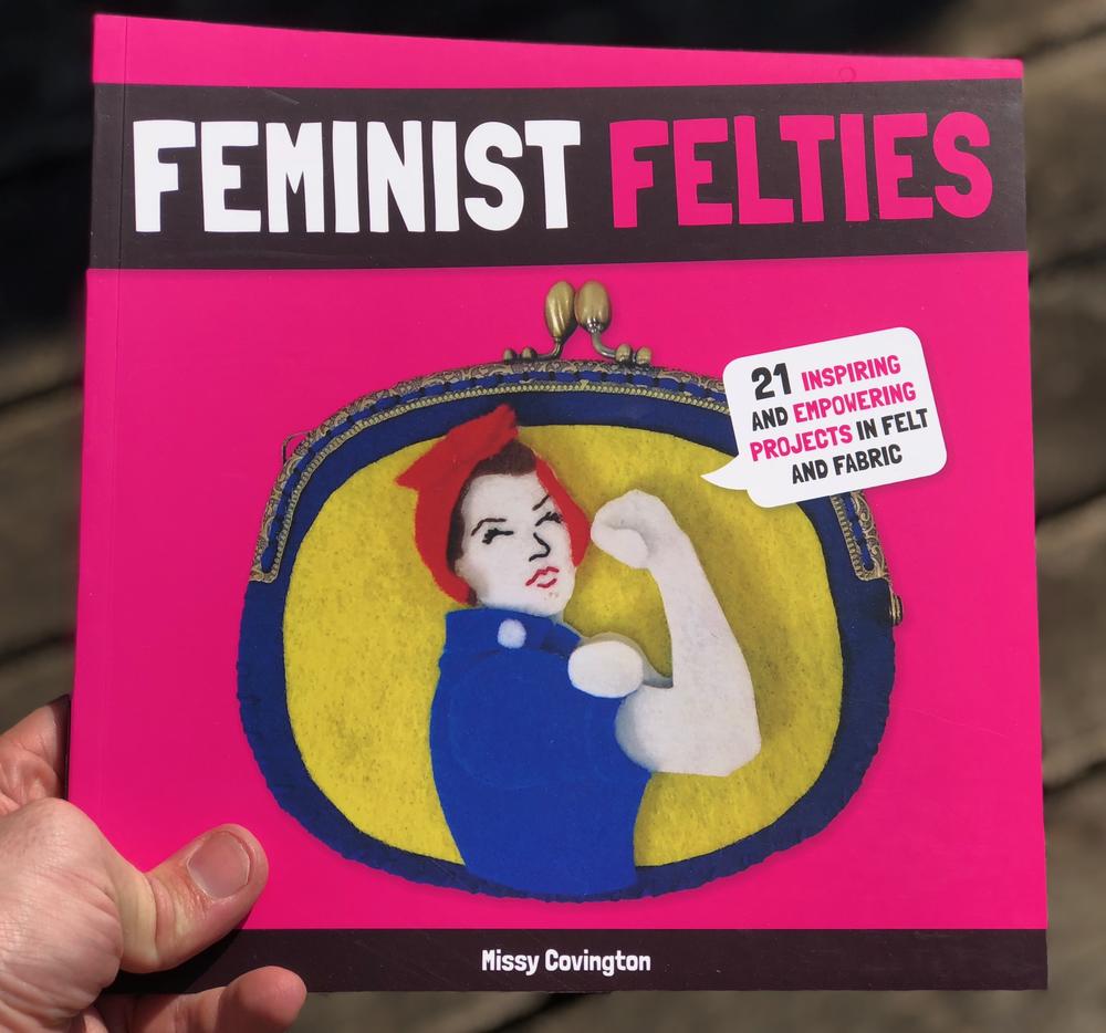 a felt cut-out of rosie the rivetter flexing