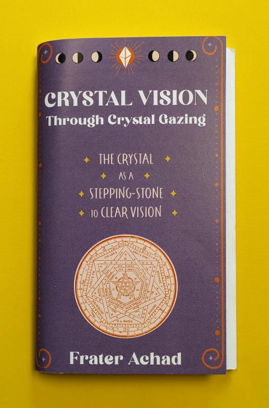 an elaborate design inside a circle at the center bottom of the cover with phases of the moon and an illustrated crystal at the top