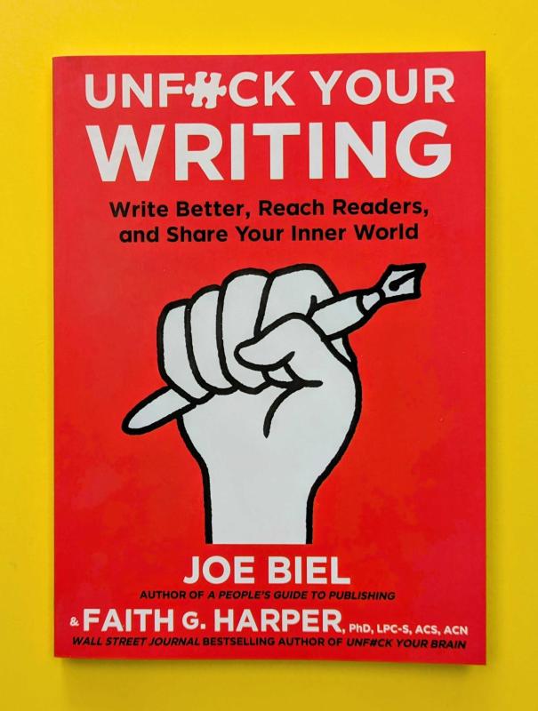 a raised fist clutches a pen