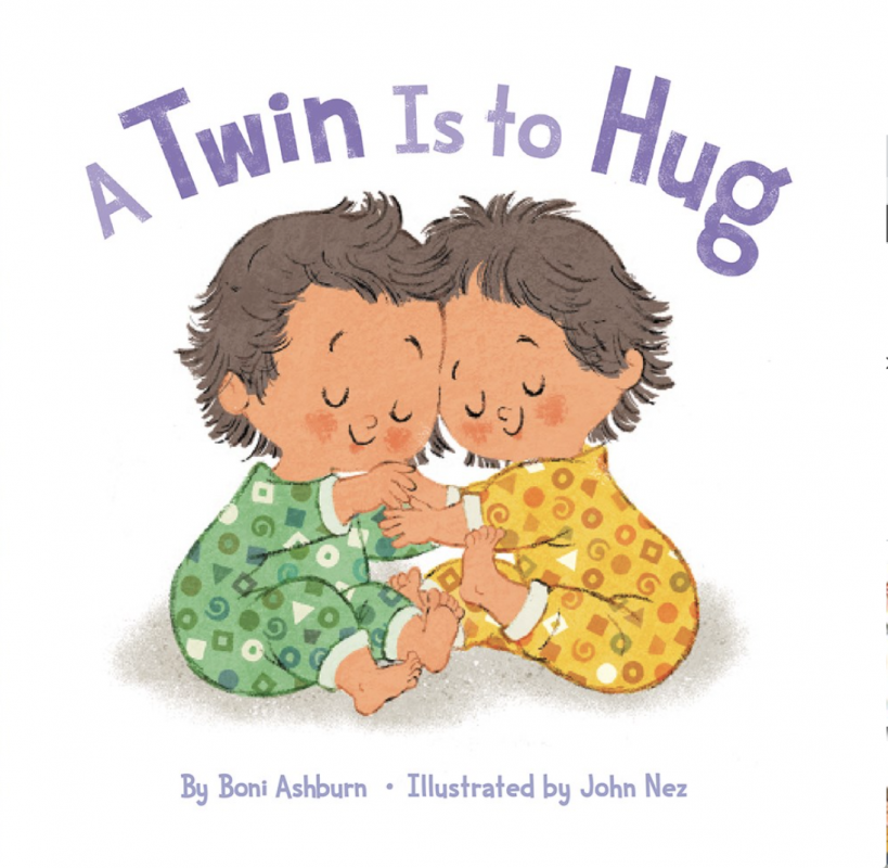 toddler twins in pajamas hugging and smiling