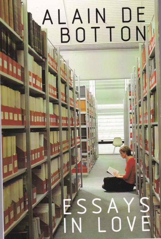 Photo of a generic French library. A woman is reading, sitting and leaning against the lefthand shelf, blocking the walkway.  An empty chair rests the perspective distance.