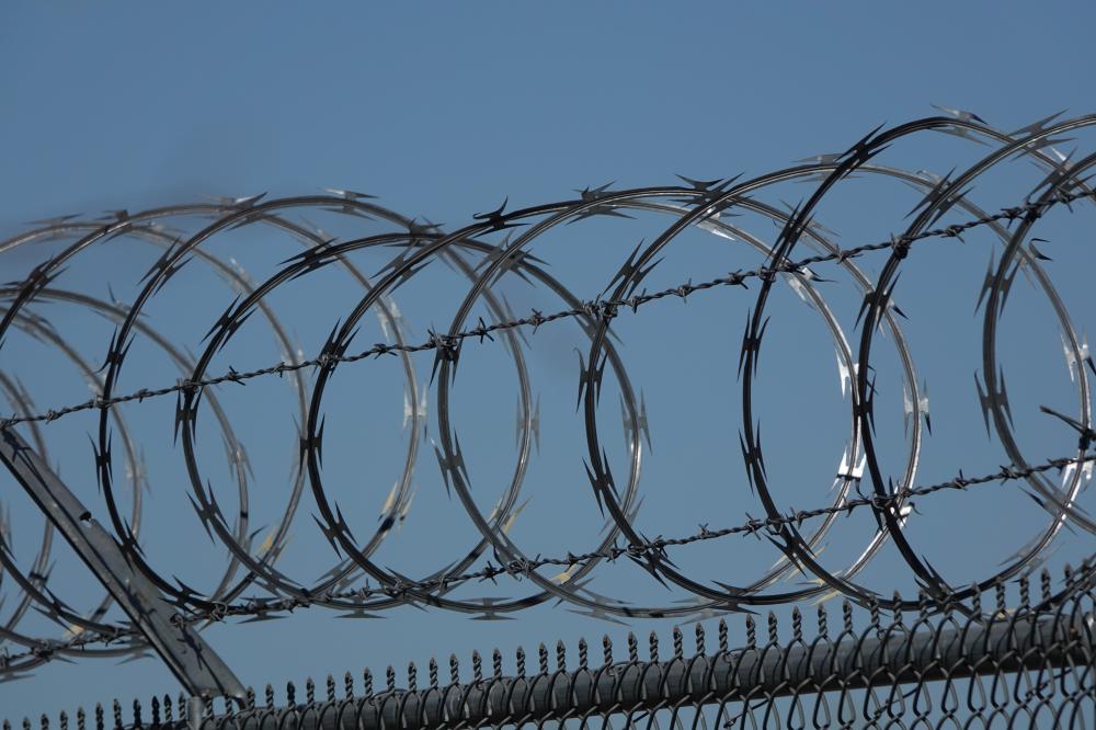 a barbed wire fence under a blue sky