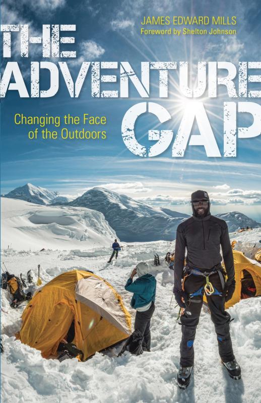 a photo of people standing outside tents with a snowy, mountainous vista in the background