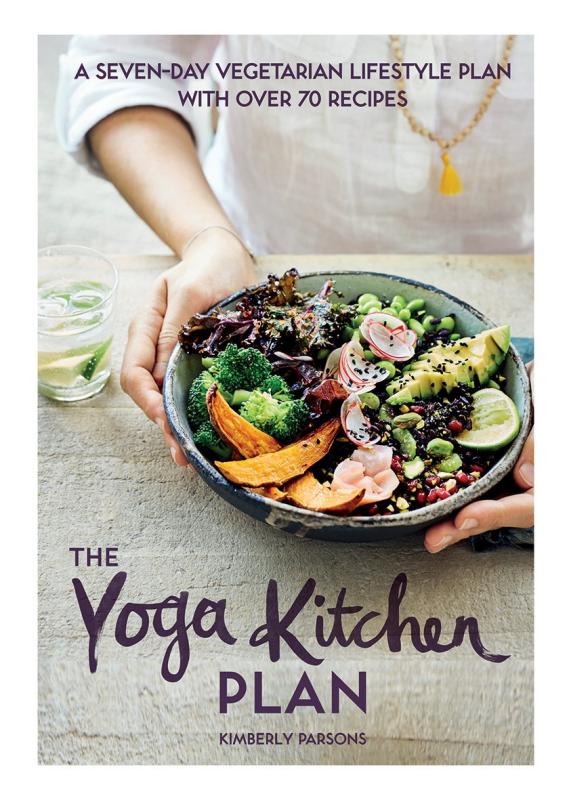 Downward perspective shot of a table, with hands holding a bowl filled with a cornucopia of vegetables and legumes.